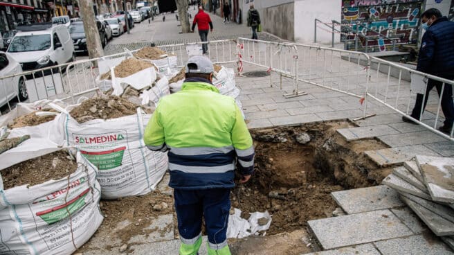 Los distribuidores de material de construcción advierten de un parón en las obras para la próxima semana Un obrero junto a unos sacos de tierra en una obra de una acera, en el centro de Madrid.