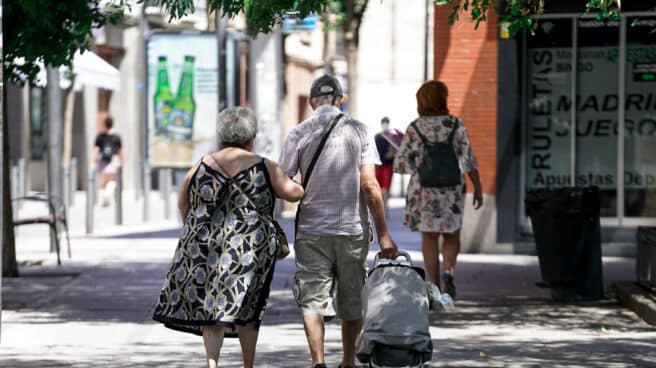 El gasto en pensiones sube un 3,23% en julio Una pareja de ancianos camina por la calle con un carro de compra.