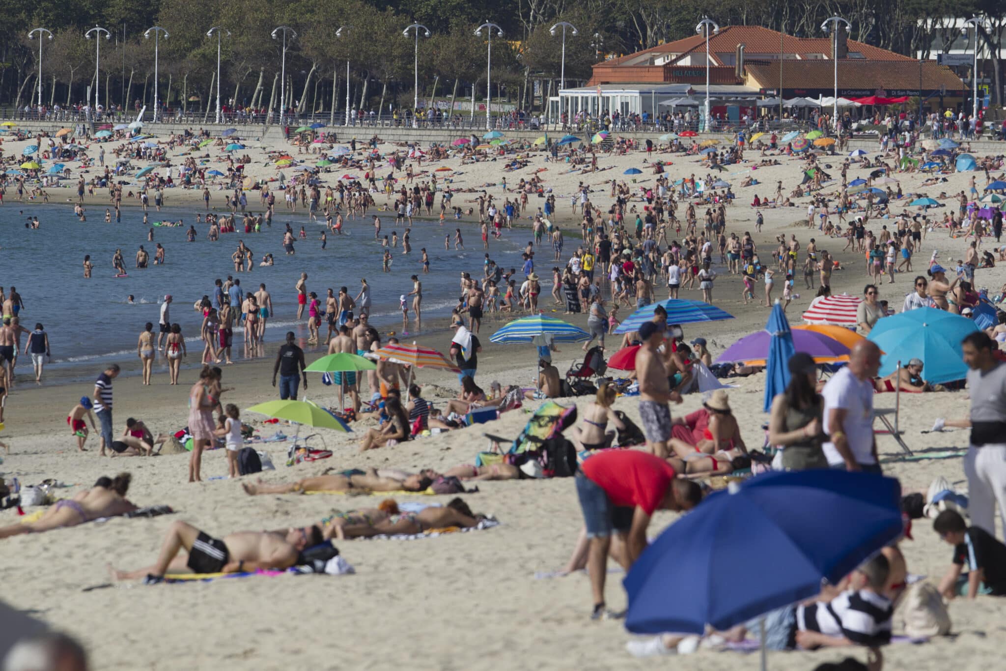 Playa de Samil en Vigo (Galicia) con mucha gente tomando el sol y disfrutando del mar.