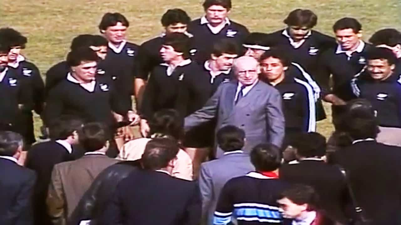 Enrique Tierno Galván, alcalde de Madrid en 1982, posa junto a los integrantes de la selección neozelandesa de rugby en el estadio Central de la Complutense