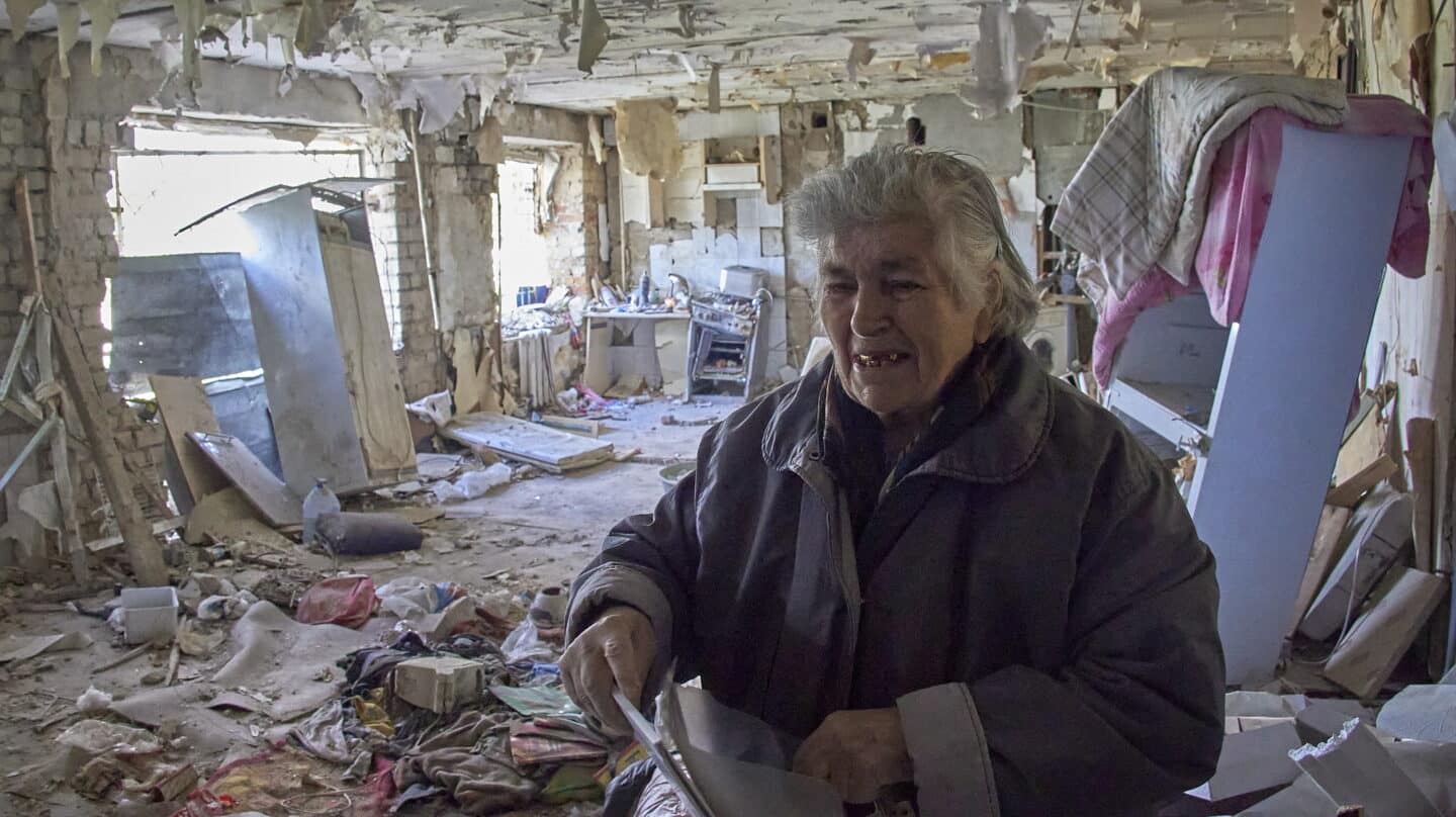Una anciana muestra su casa dañada donde fue herido su hijo