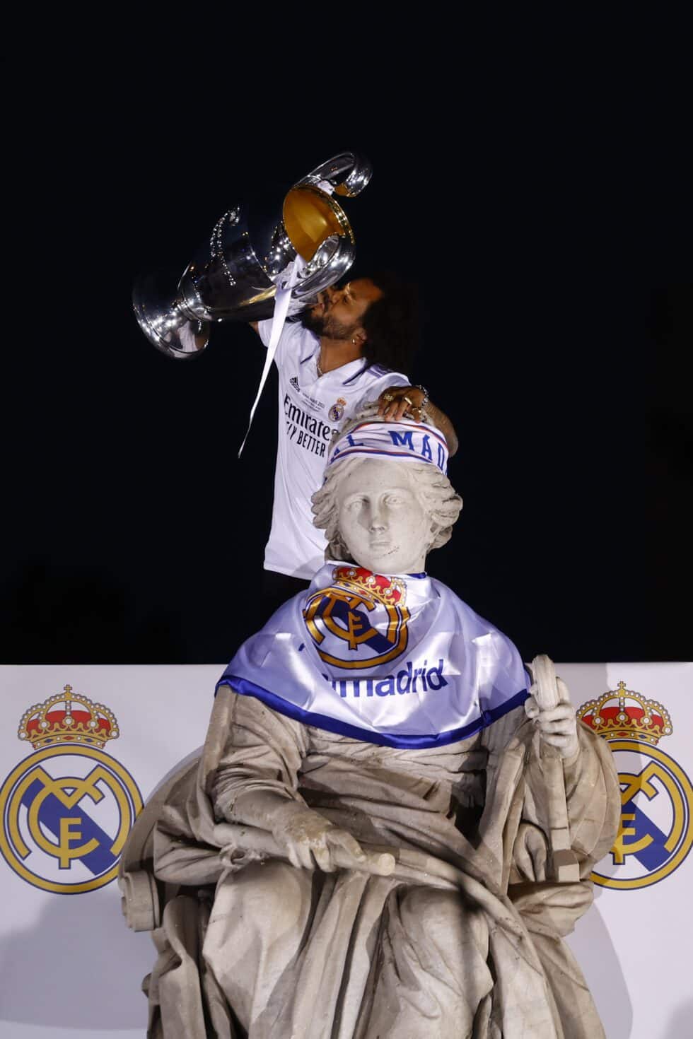 El capitan del Real Madrid Marcelo Vieira levanta la copa tras poner una bufanda a la diosa Cibeles
