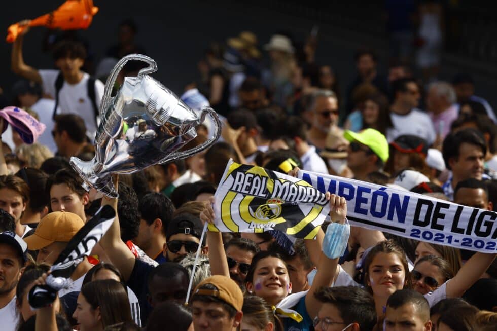 Aficionados del Real Madrid esperan la llegada del equipo blanco a la madrileña plaza de Cibeles