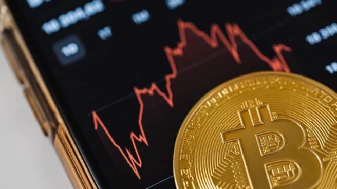 Representación gráfica de bitcoins, criptomonedas, frente a gráficos de la bolsa