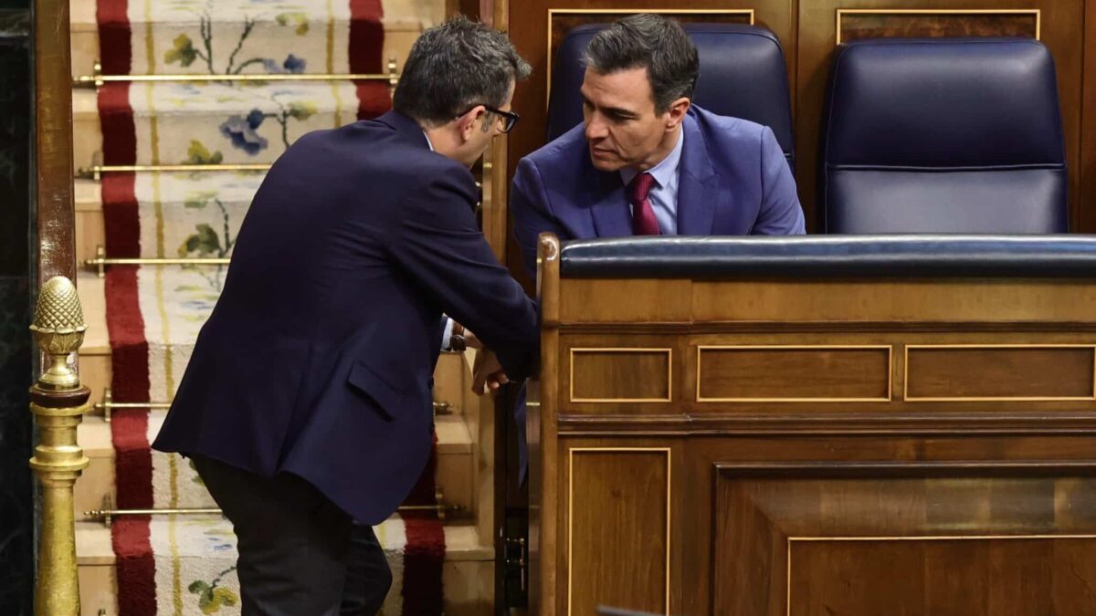 El ministro de la Presidencia, Félix Bolaños, habla con Pedro Sánchez en los escaños del Congreso.