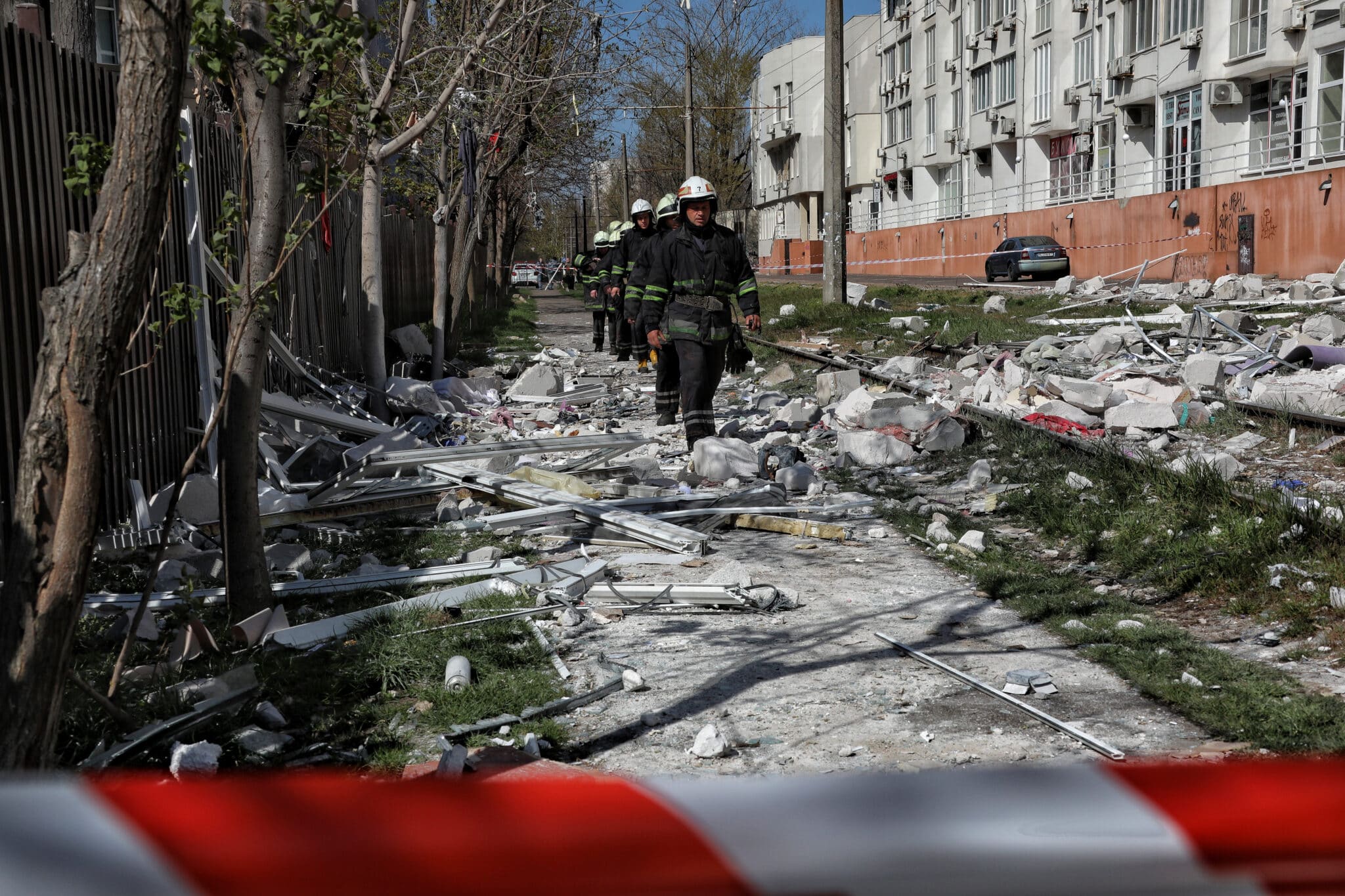 Bomberos caminan por una calle destruida en Odesa