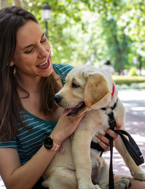 Natalia posa con Goofy, un cachorro de labrador que está entrenando para ser perro guía