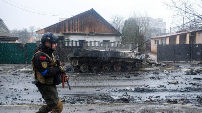 Un soldado ucraniano junto a un tanque ruso destruido en Bucha (Ucrania)