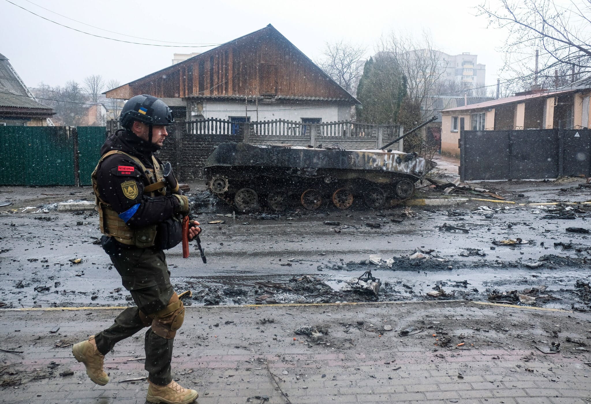 Un soldado ucraniano junto a un tanque ruso destruido en Bucha (Ucrania)