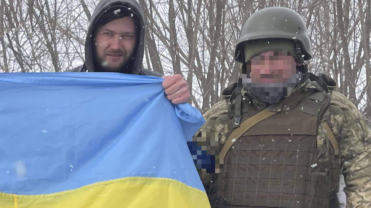 Andrej Kidanchuk con la bandera ucraniana junto a un soldado