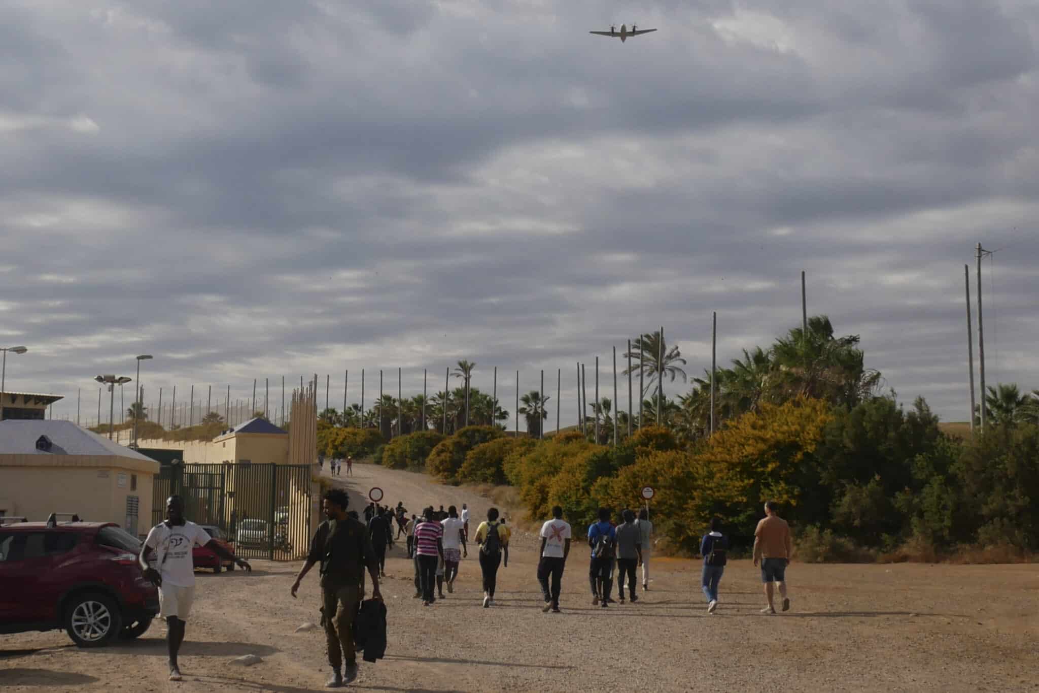 Varias decenas de inmigrantes se dirigen al Centro de Estancia Temporal de inmigrantes (CETI) tras entrar este viernes en Melilla tras romper la puerta de acceso al paso fronterizo de Barrio Chino y saltar por encima de su tejado que separa la ciudad autónoma de Marruecos.