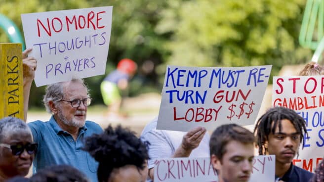 Padres e hijos sostienen carteles mientras el grupo pide al gobernador republicano de Georgia, Brian Kemp, que devuelva las contribuciones de campaña denunciadas por Daniel Defense, el fabricante de armas del rifle estilo AR-15