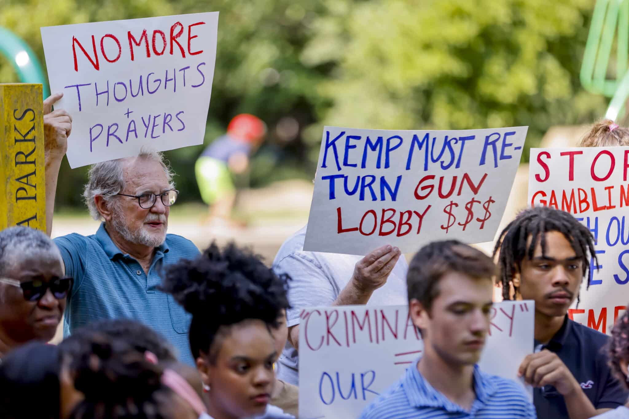Padres e hijos sostienen carteles mientras el grupo pide al gobernador republicano de Georgia, Brian Kemp, que devuelva las contribuciones de campaña denunciadas por Daniel Defense, el fabricante de armas del rifle estilo AR-15