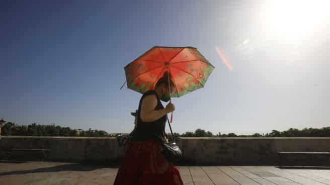 Una DANA procedente de las Azores podría acabar con la ola de calor este fin de semana Una mujer se protege con un paraguas de las altas temperaturas mientras pasea por el puente Romano de Córdoba