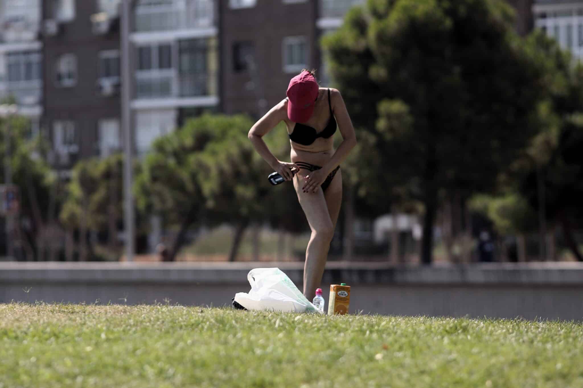 Una mujer se administra protección solar en el Parque Madrid Río, a 29 de julio de 2020. Una ola de calor llegará mañana a la Península y Baleares, dejando temperaturas de 40ºC