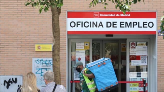 Un repartidor pasa por una oficina del SEPE en Madrid.