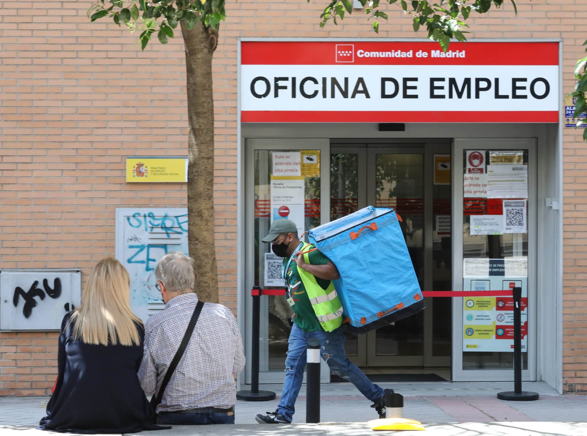 Un repartidor pasa por una oficina del SEPE en Madrid.