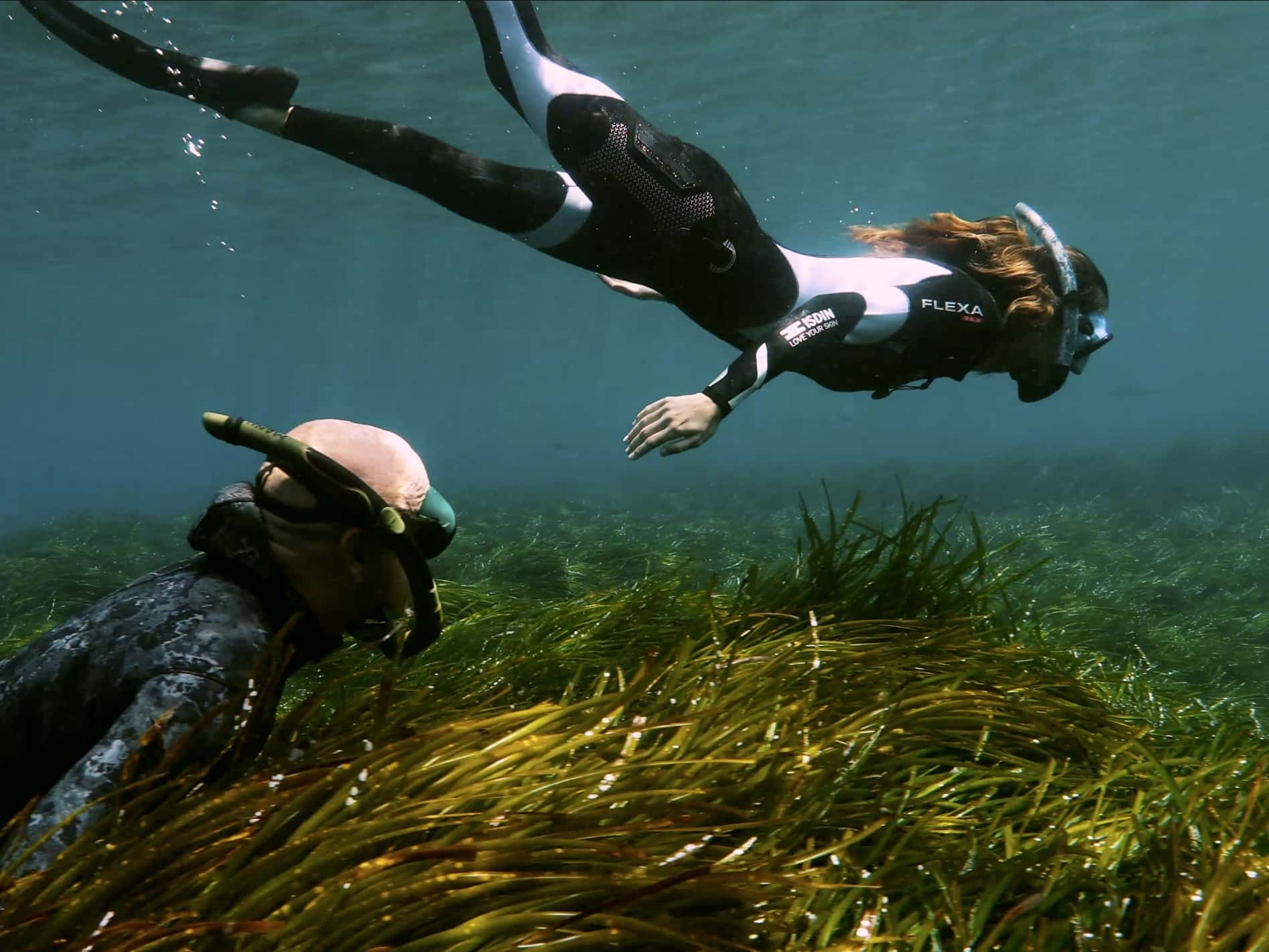 Los embajadores de ISDIN Manu Sanfélix y Ona Carbonell, rodeados de posidonia en el Mediterráneo