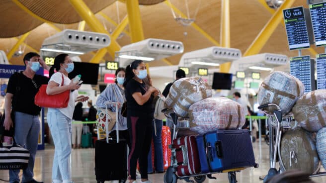 Viajeros esperan para facturar sus maletas en Barajas. Viajeros esperan para facturar sus maletas en Barajas.