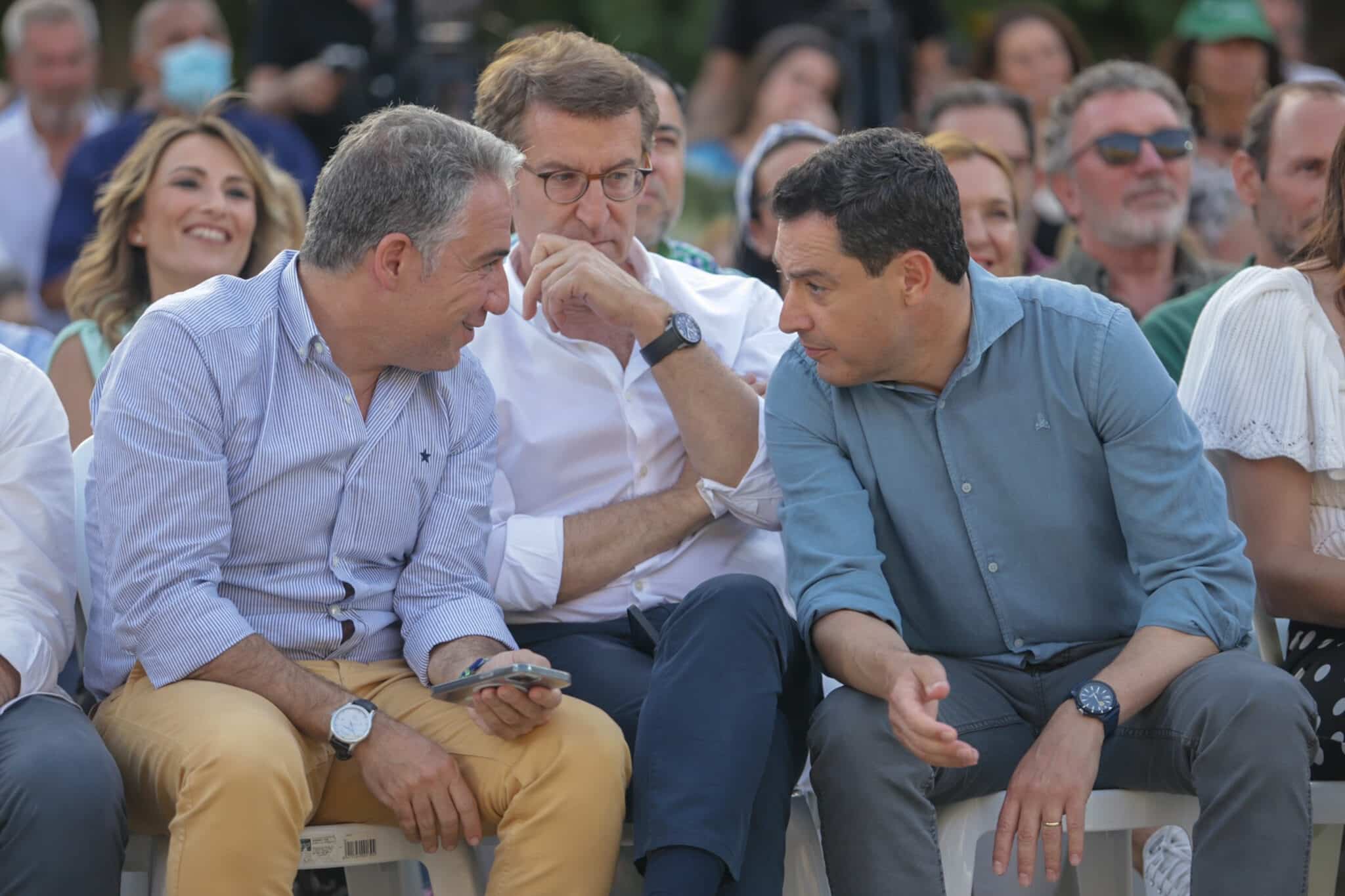 Juanma Moreno habla con Elías Bendodo en presencia de Núñez Feijóo el sábado en un mitin en Málaga.