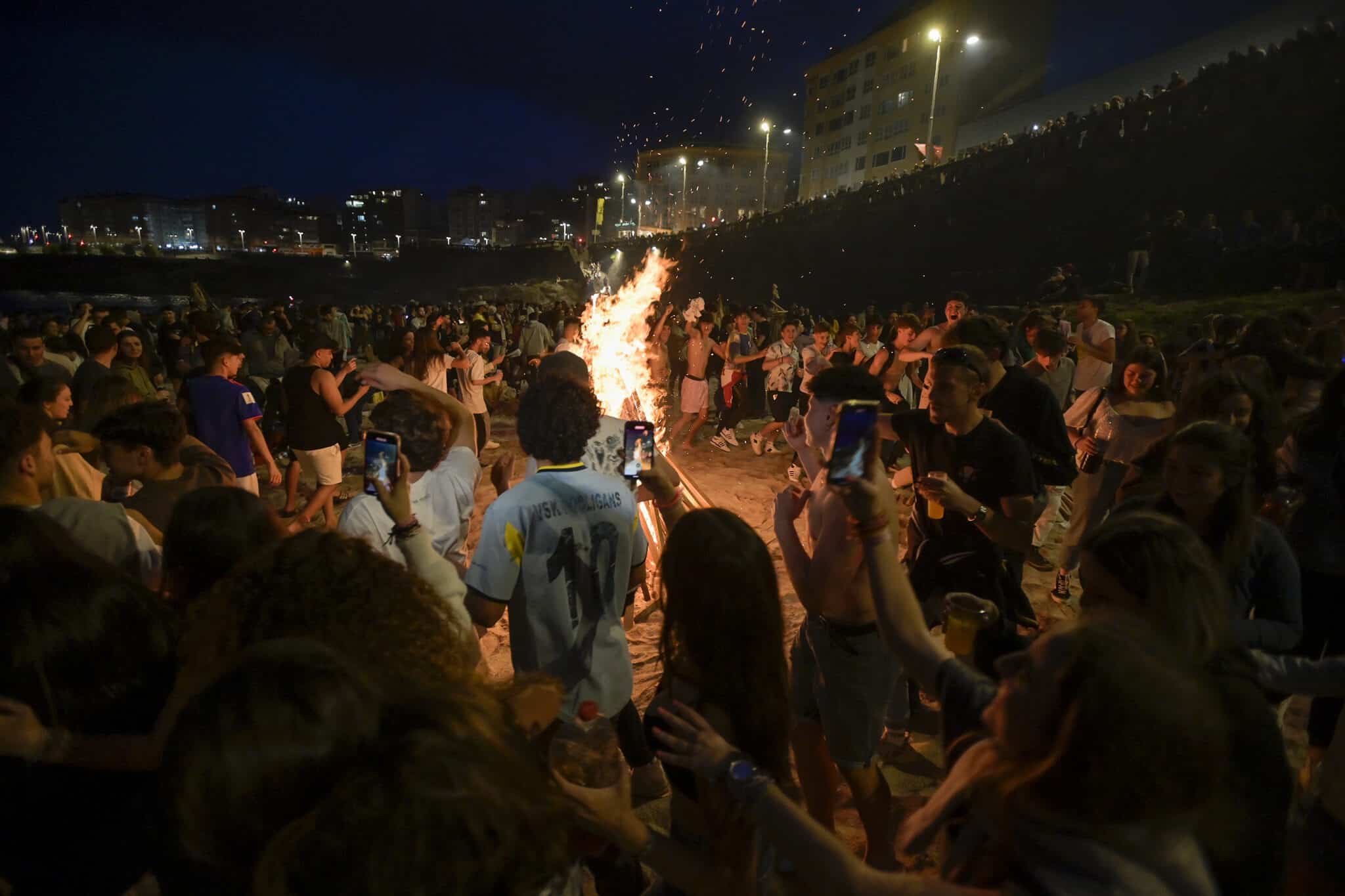 Centenares de personas frente a una hoguera en la Noche de San Juan, a 23 de junio de 2022, en A Coruña, Galicia