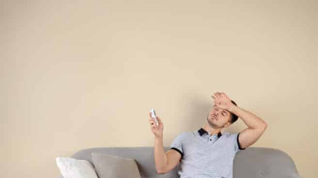 Los mejores aires acondicionados portátiles de Taurus Hombre sentado en un sofá pasando calor