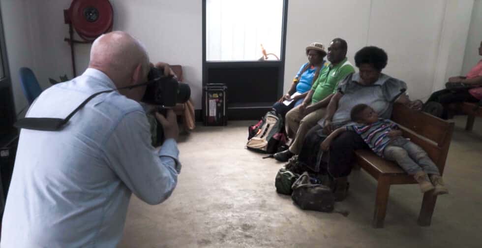 Steve McCurry fotografiando a una familia sentada en un banco