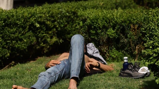 Un hombre tumbado en el césped al sol en Madrid