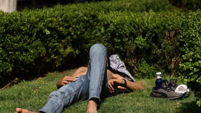Un hombre tumbado en el césped al sol en Madrid Un hombre tumbado en el césped al sol en Madrid