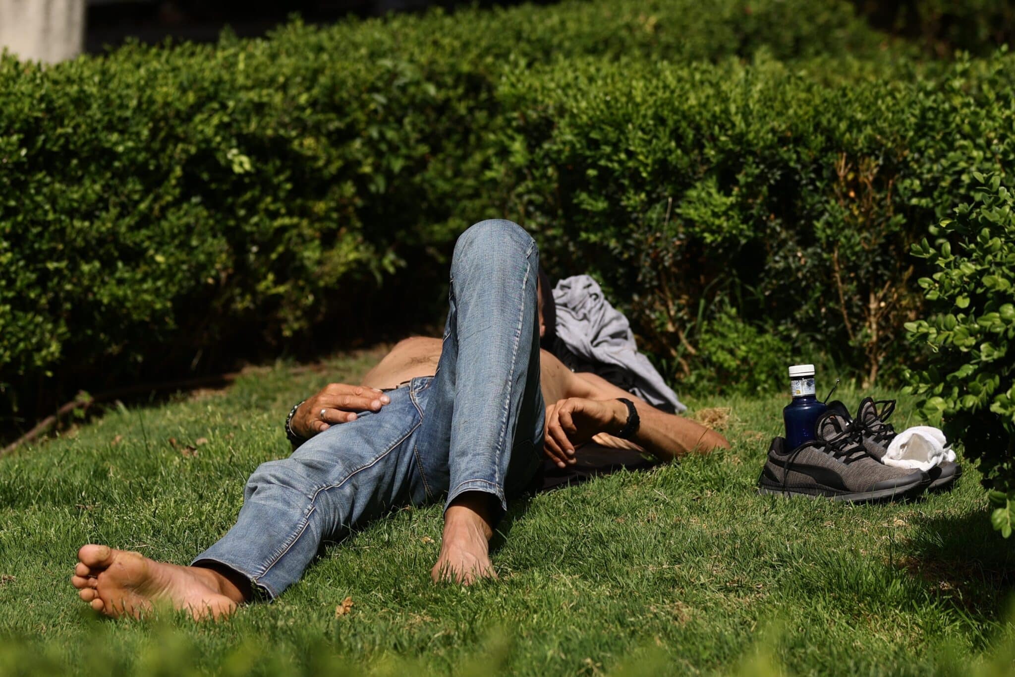 Un hombre tumbado en el césped al sol en Madrid