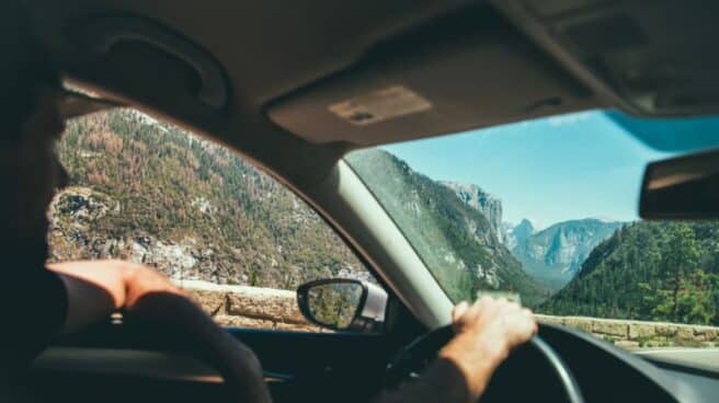 Acciones por las que te pueden multar mientras conduces Interior de un coche desde el que se ve una persona conduciendo