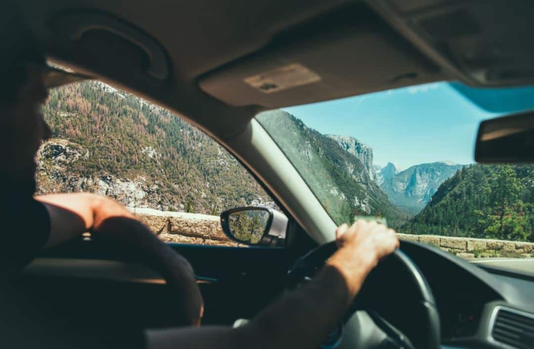 Interior de un coche desde el que se ve una persona conduciendo