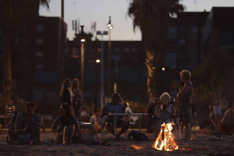 Mujeres celebrando la noche de San Juan 2022 en las playas de La Malvarrosa y Las Arenas (Valencia) con las hogueras típicas encendidas