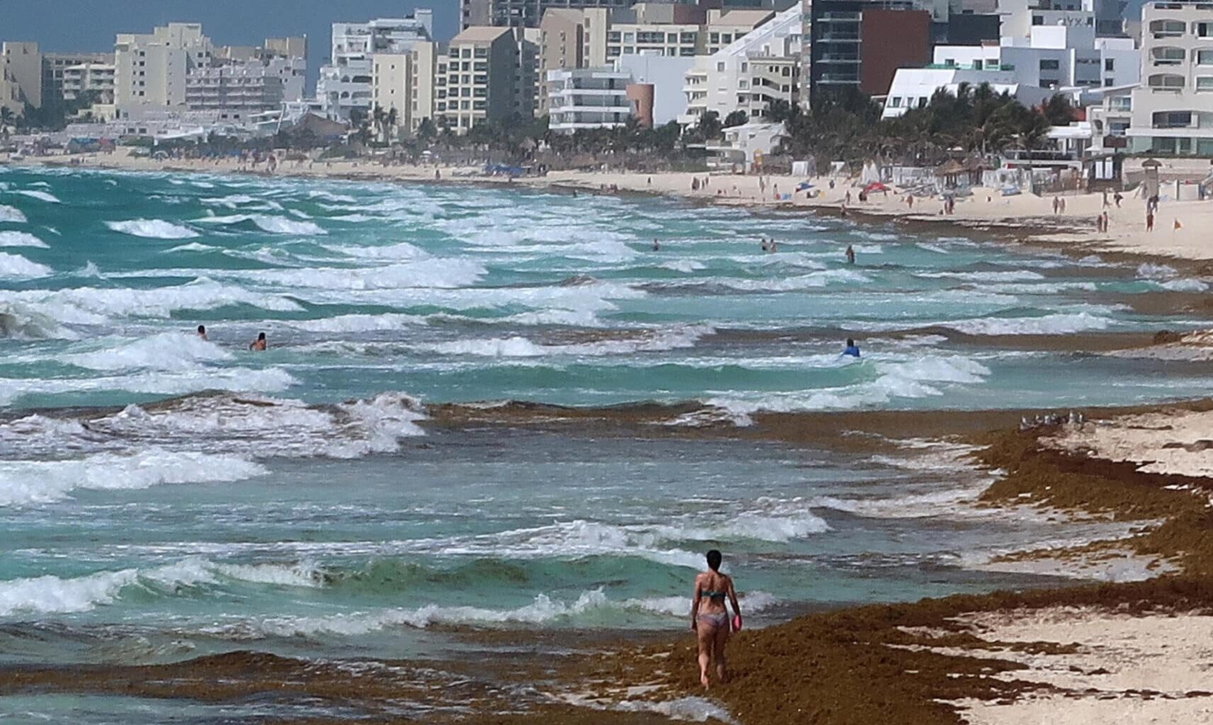 Fotografía del 21 de mayo de 2022 donde se observa una vista general de una playa con sargazo, en el balneario de Cancún en Quintana Roo (México).