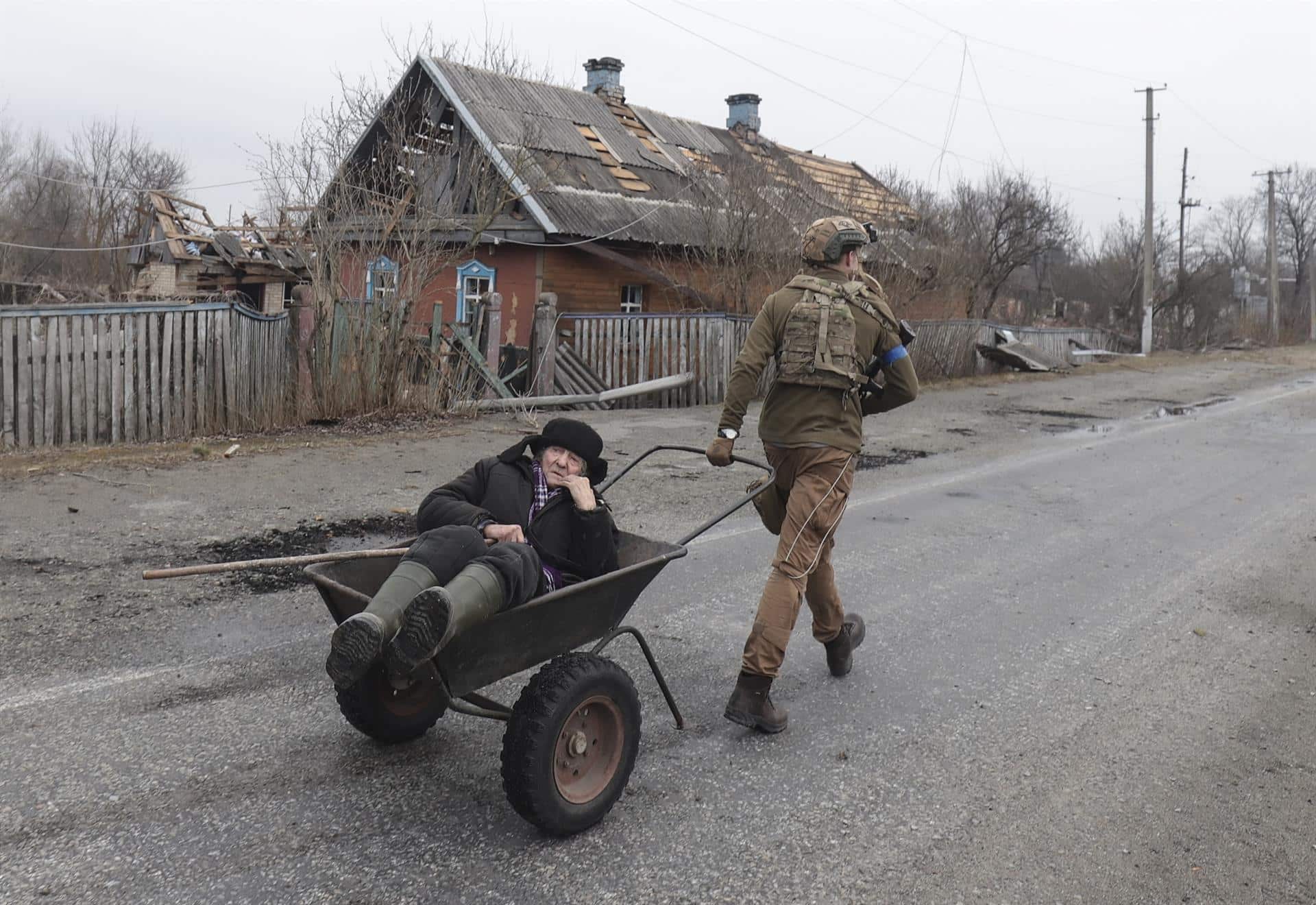 Un soldado ucraniano evacúa a un anciano de su hogar, destruido por las bombas, en Kiev