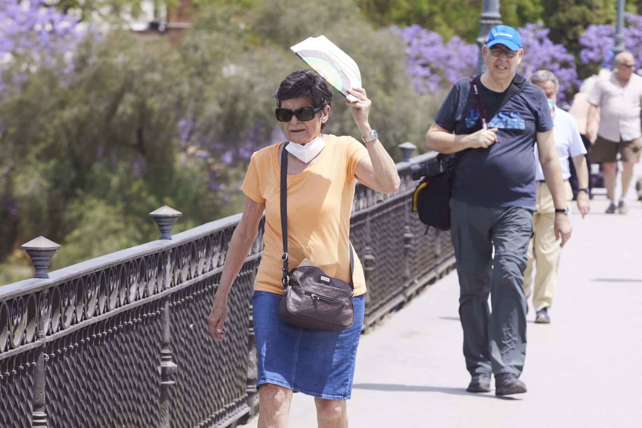 Una señora se protege del sol en Sevilla