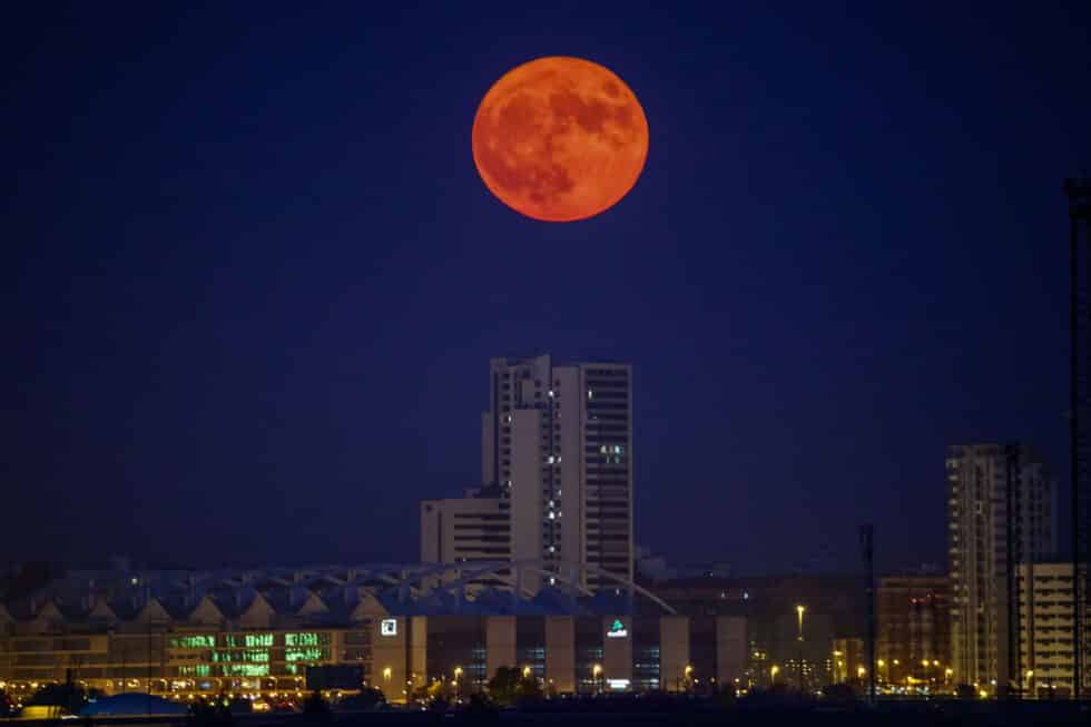 La luna llena sale junto al edificio Torre Zaragoza en la capital aragonesa.
