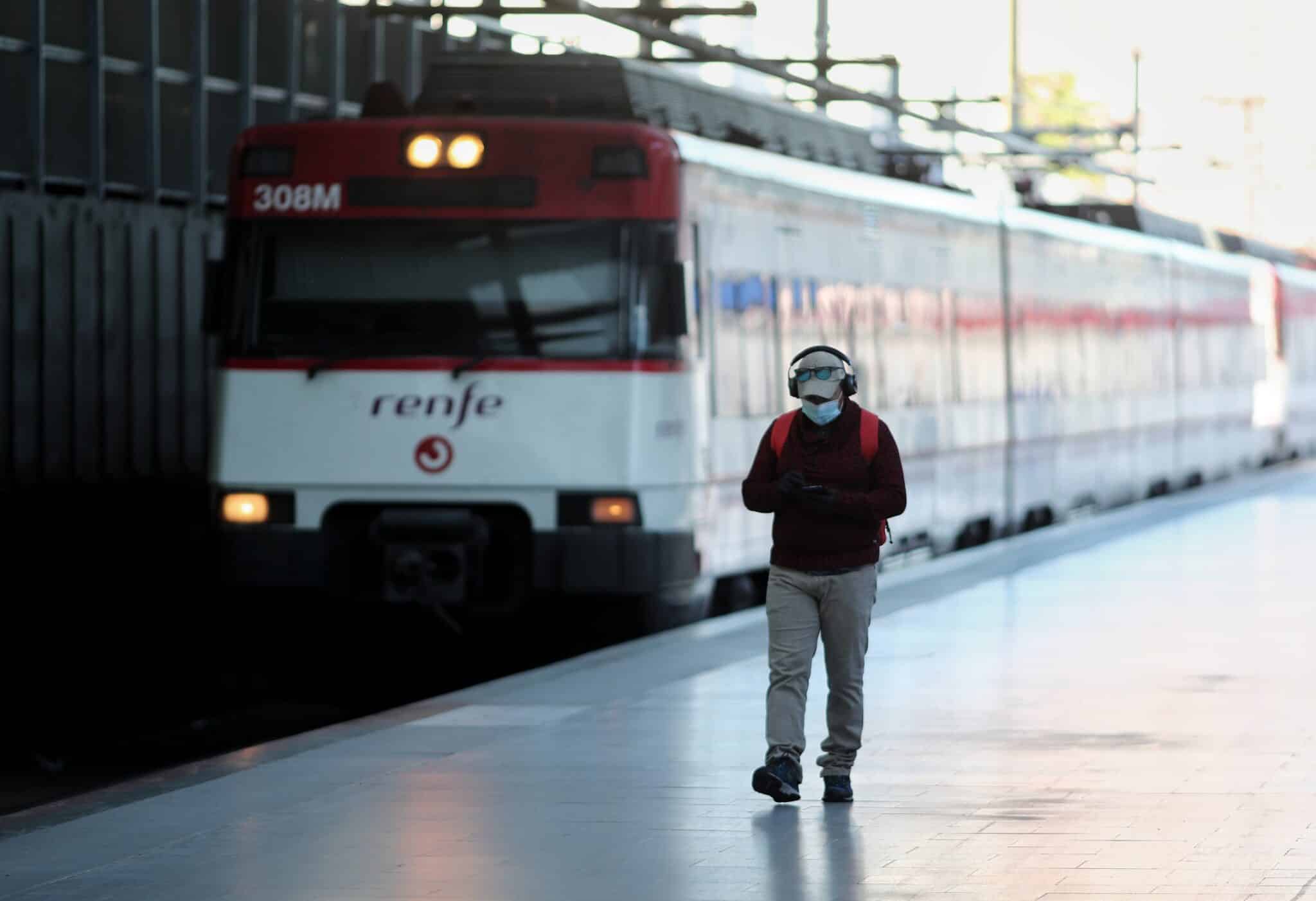 Un hombre camina por un andén frente a un tren de Cercanías de Renfe.