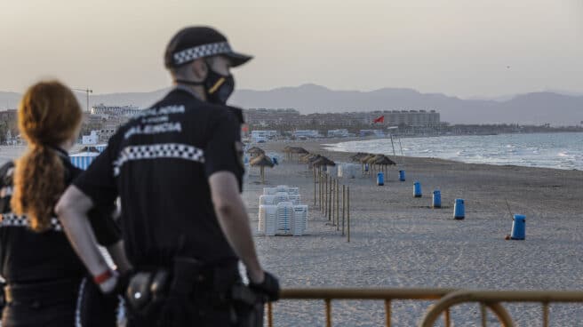 Dos policías locales contemplan la playa de la Malvarrosa