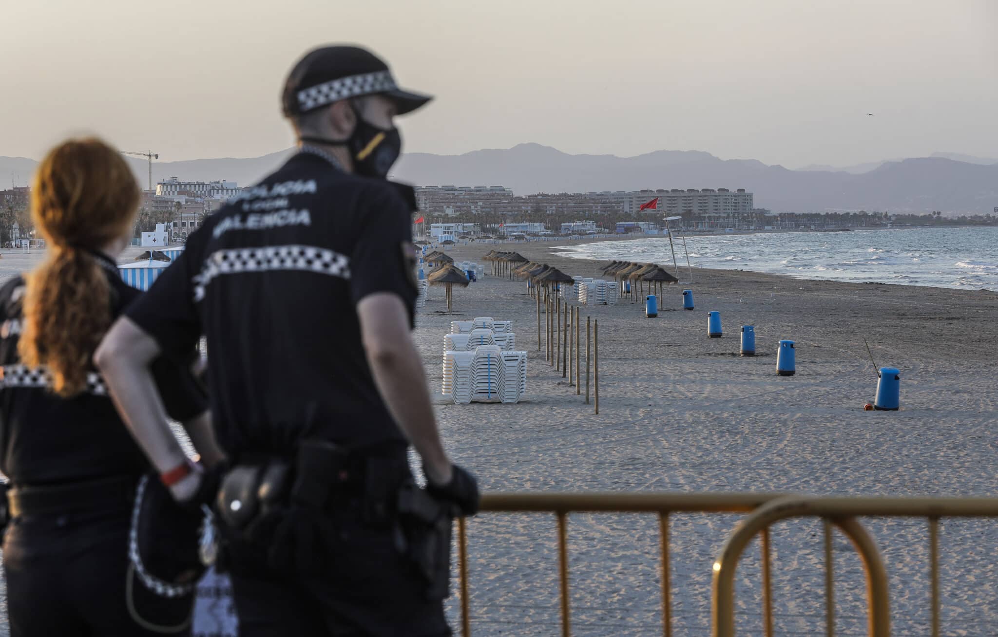 Dos policías locales contemplan la playa de la Malvarrosa