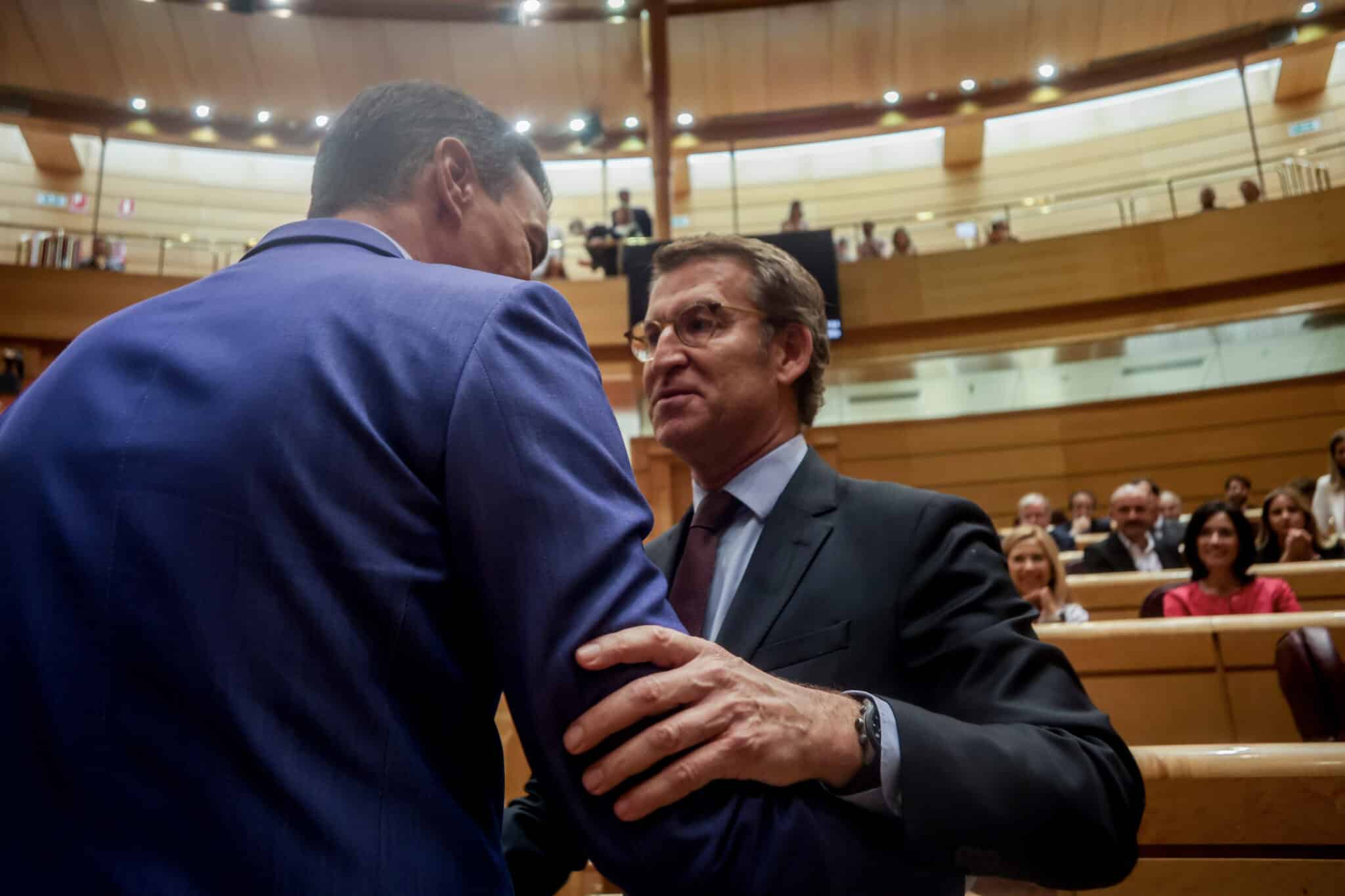 El presidente del Gobierno, Pedro Sánchez (i), y el líder del PP, Alberto Núñez Feijóo (d), se saludan en una sesión plenaria en el Senado.