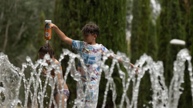 Dos niños se mojan entre ellos en los chorros de Madrid Río, a 16 de junio de 2022