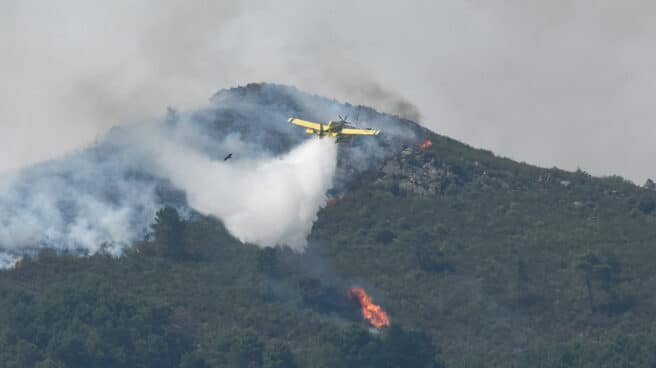 Un hidroavión anfibio contra incendios echa agua sobre la vegetación en Extremadura