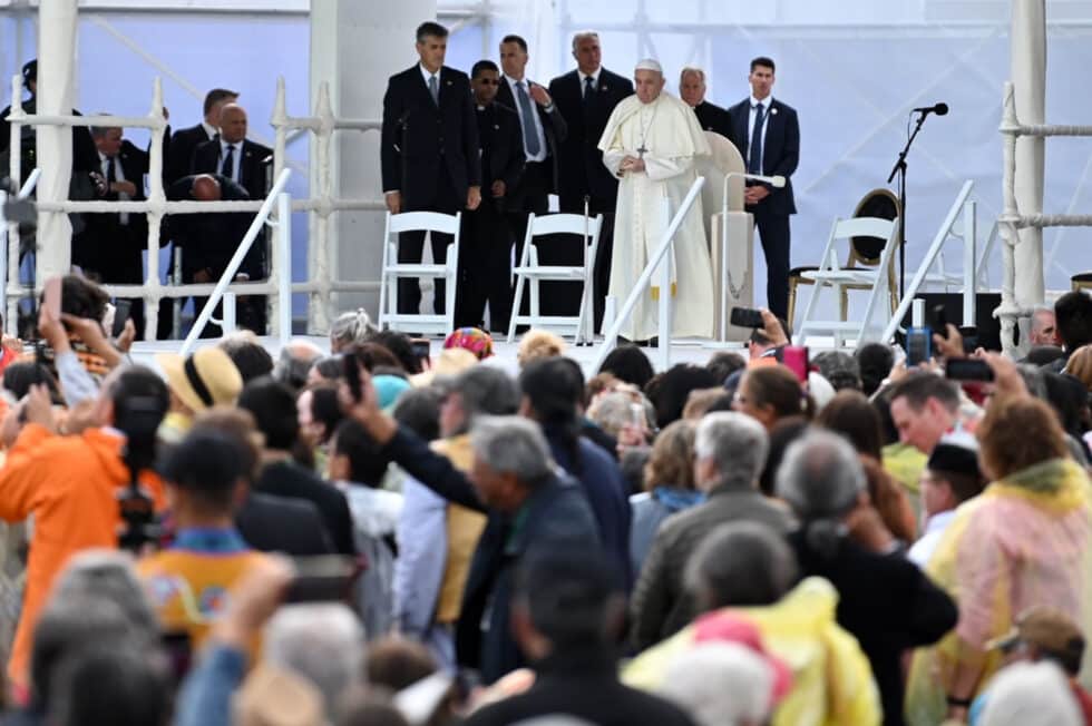 El Papa Francisco se encuentra en un escenario con el tradicional tocado de plumas durante su visita para reunirse con los indígenas del país