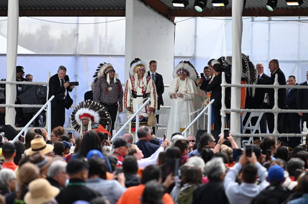 El Papa Francisco se encuentra en un escenario con el tradicional tocado de plumas durante su visita para reunirse con los indígenas del país