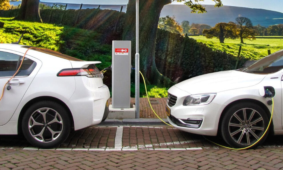 Dos coches estacionados realizando una carga de batería