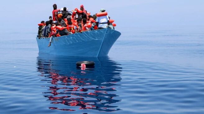 Una embarcación con numerosos inmigrantes a bordo, navegando por el Mediterráneo central.