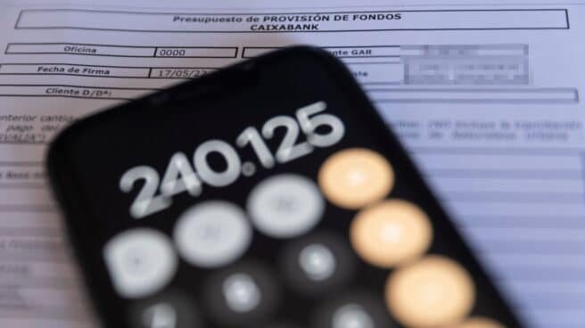 hipoteca-escritura (1) Una calculadora y una escritura de compraventa de una hipoteca.