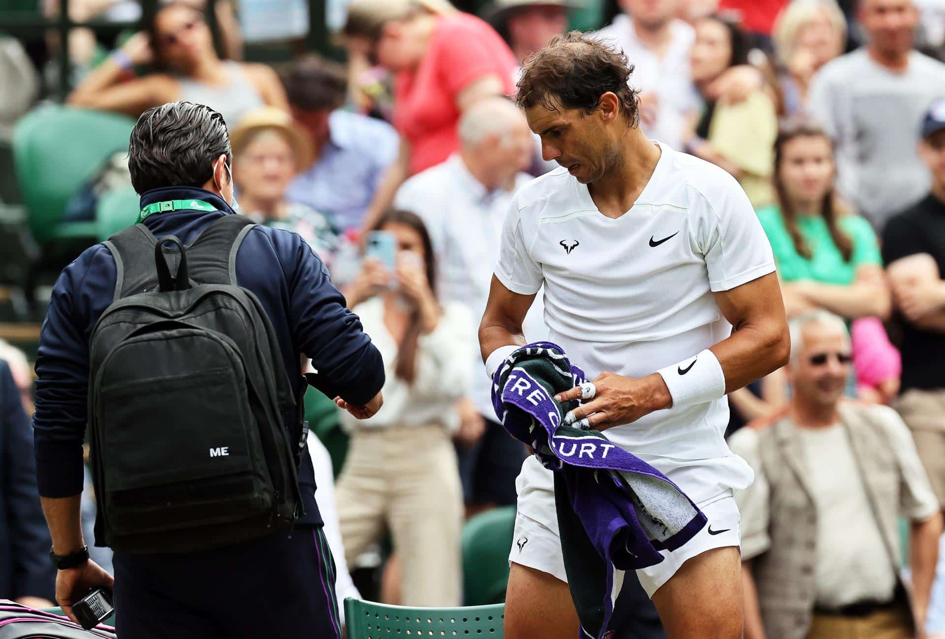 Nadal, junto al médico durante su partido contra Taylor Fritz en los cuartos de final de Wimbledon.