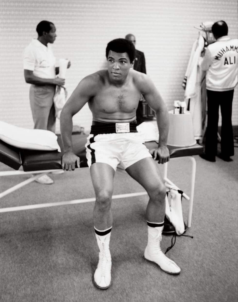 En el vestuario antes del combate. El comportamiento de Ali era relajado y contrastaba con el estado de ánimo sombrío de su equipo. "Vamos a bailar", exclamó Ali según recoge Norman Mailer.